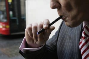 Managing Director of The Electronic Cigarette Company smokes an electronic cigarette as he poses for the photographer in London