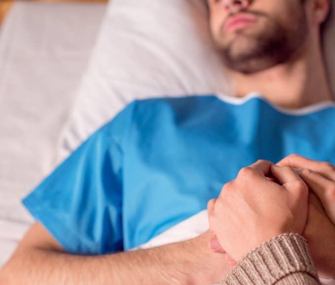 sick man in a hospital bed
